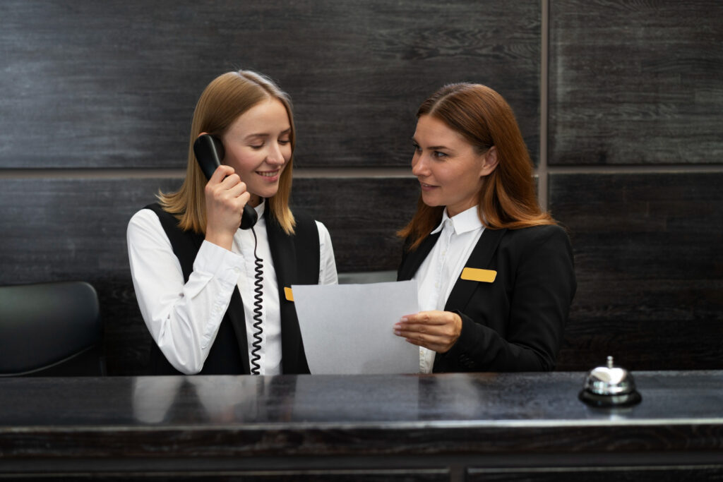 Hotelrezeptionistinnen im Gespräch und Telefonservice am Empfang