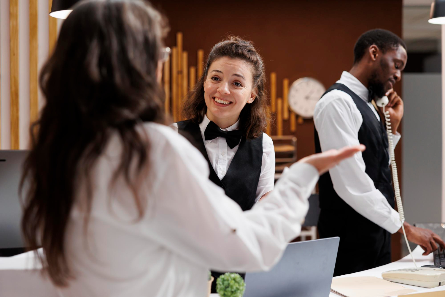 Hotelrezeptionsteam im Gespräch und Telefonservice am Empfang